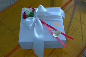 Confezionamento con nastro bianco e fiori rossi